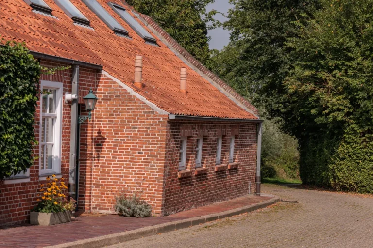 Altes ostfriesisches Klinkerhaus mit rotem Ziegeldach in Pilsum